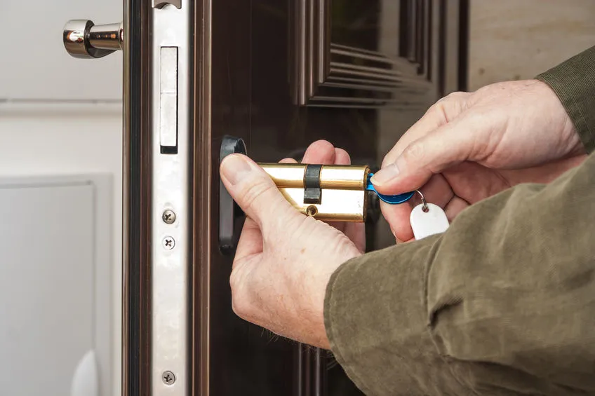 locksmith inserting a key into a lock